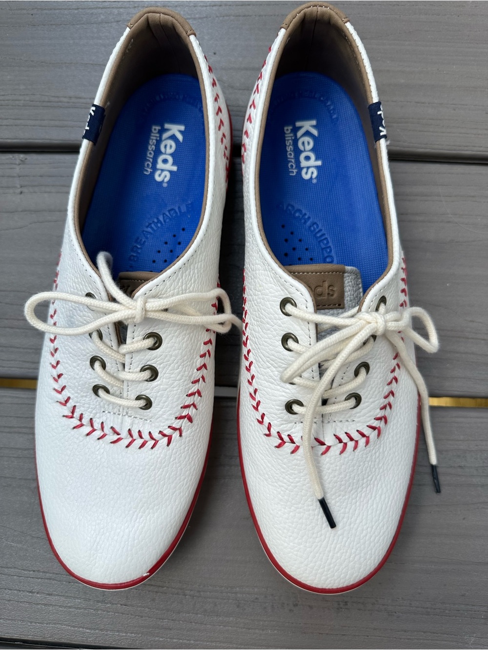 Keds womenโs leather White Sneakers with Red Stitch Accent